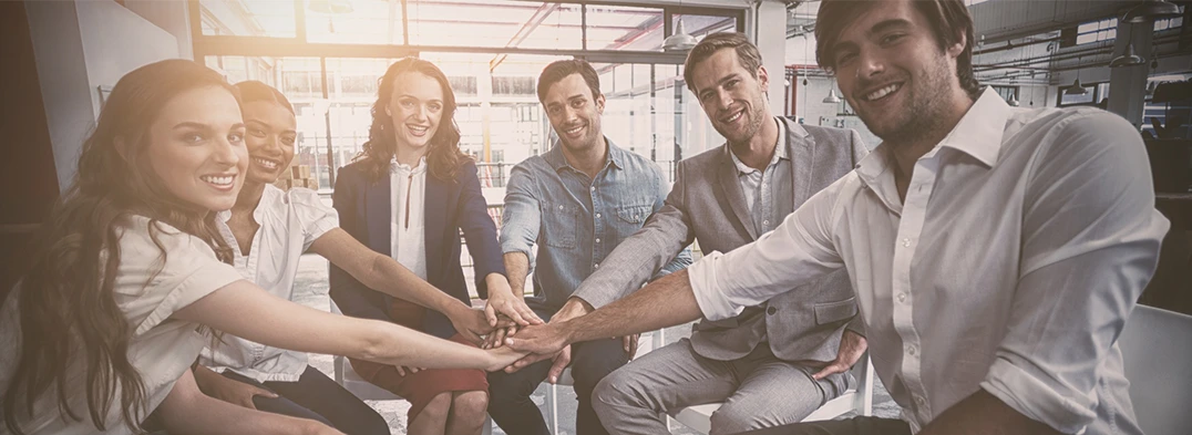 Anti Stress Coaching für Firmen Gruppe von jungen Frauen und Männern im Business-Outfit fügen Ihre Hände zusammen