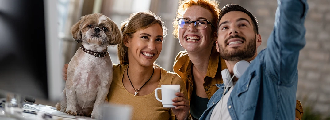 Anti Stress Coaching für Firmen zwei Frauen, ein Mann und ein Hund nehmen gemeinsam ein Foto auf - Alexander Klein